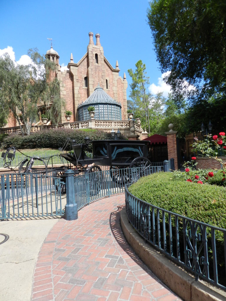 Haunted Mansion horseless carriage in front the Disney dark ride. Keep reading to learn about the Disney Haunted Mansion Magic Bands.