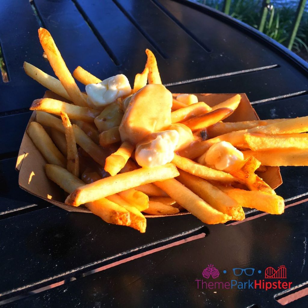 Canada Poutine with Fries Gravy and Cheese Curds on Black Table Available All Year at The Daily Poutine. One of the best quick service restaurants in Disney Springs.