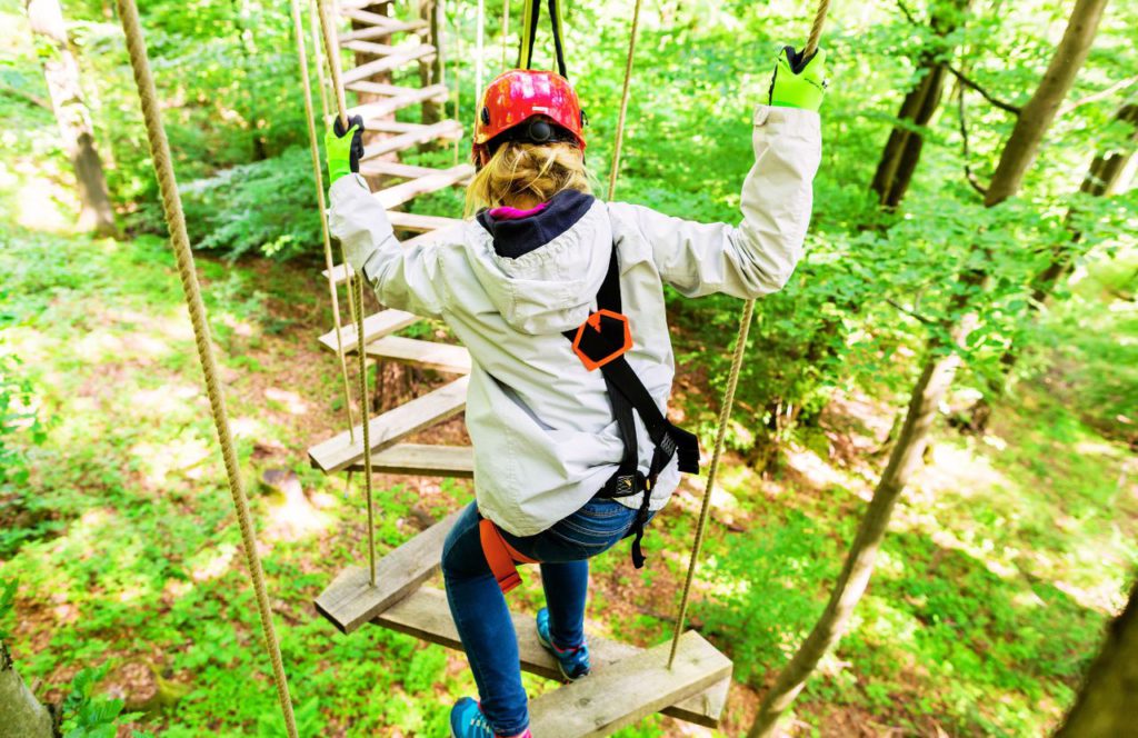 Orlando Tree Trek with lady crossing high ropes. One of the most adventurous things to do in Orlando, Florida