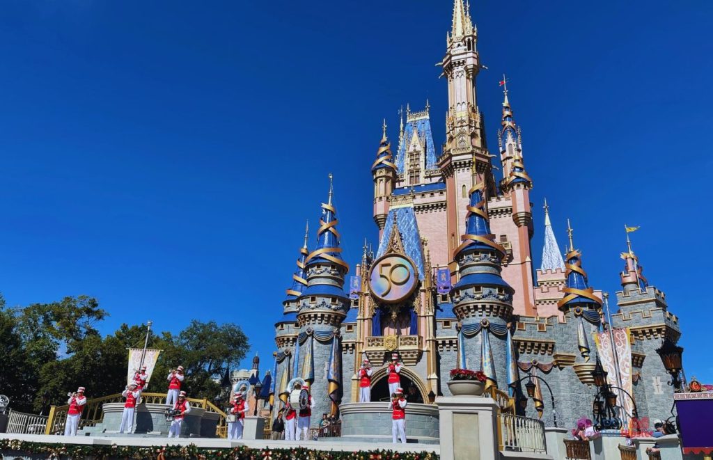 Cinderella Castle for 50th Anniversary Celebration with the Magic Kingdom Band Performing on the Stage. with ThemeParkHipster.