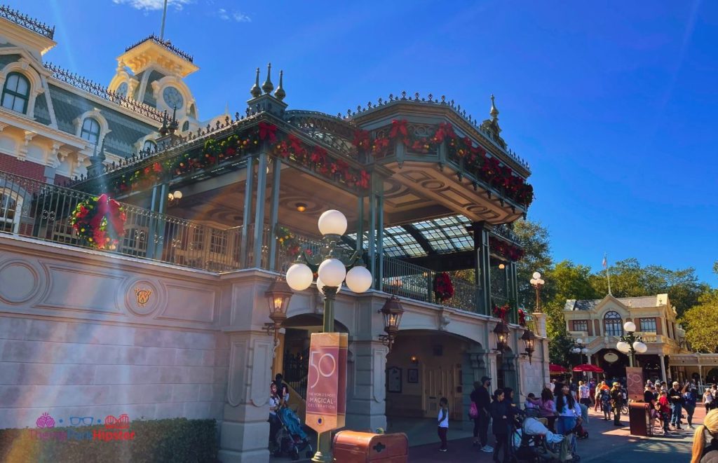 Disney Magic Kingdom Holiday Decor on Train Station on Main Street USA. Keep reading to get the best Disney at Christmastime tips for your trip!