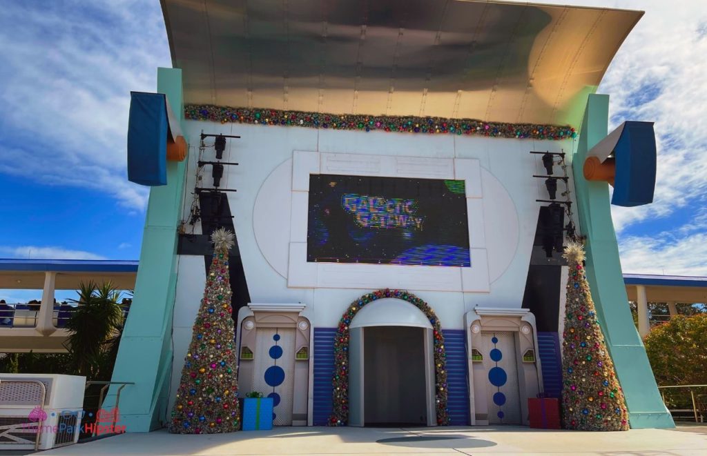 Disney Magic Kingdom Tomorrowland Galactic Gateway Stage with Silver Christmas Trees. Keep reading to learn more about your Disney Christmas trip and the Disney Christmas decorations.