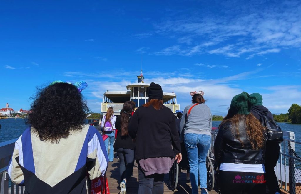 Disney Magic Kingdom Walking onto the Ferry Boat. Keep reading to get the best Disney at Christmastime tips for your trip!