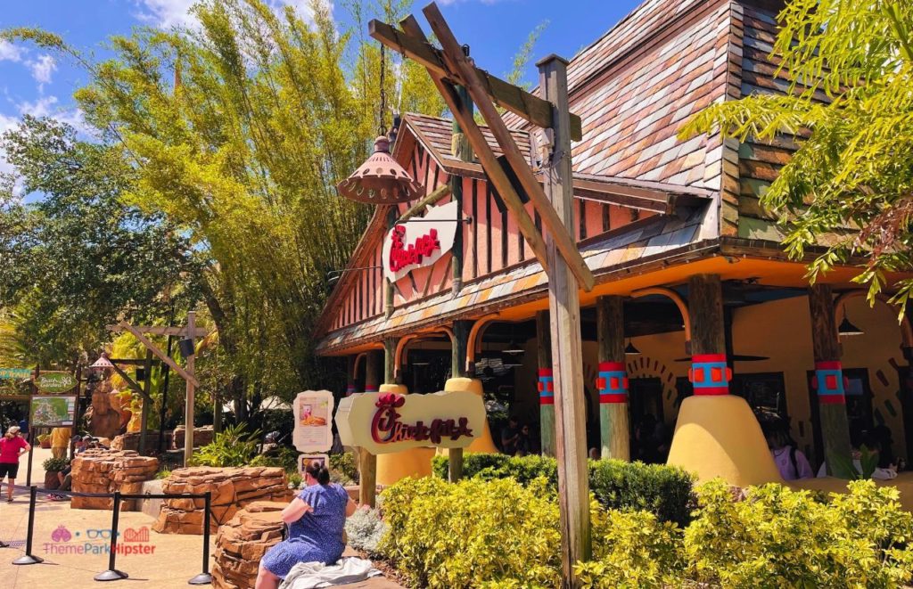 Busch Gardens Tampa Bay lady sitting in front of Chick fil la. Going to Busch Gardens alone doesn't have to be scary. Keep reading for more solo travel tips.