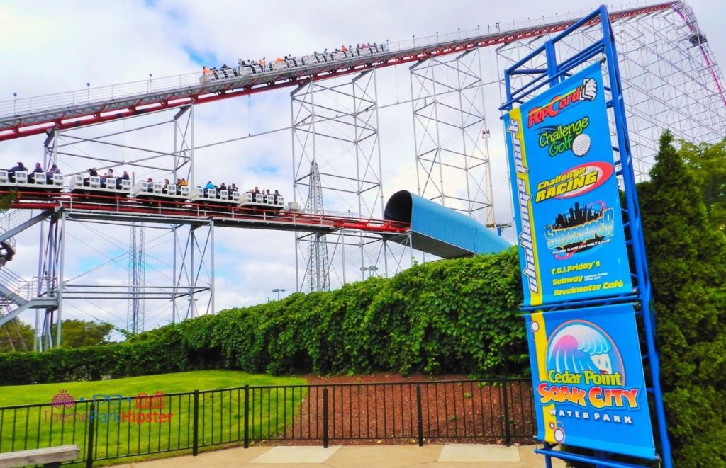 Cedar Point Magnum XL lift hill and tunnel on roller coaster with soak city sign. Keep reading to learn about the best Cedar Point rides.