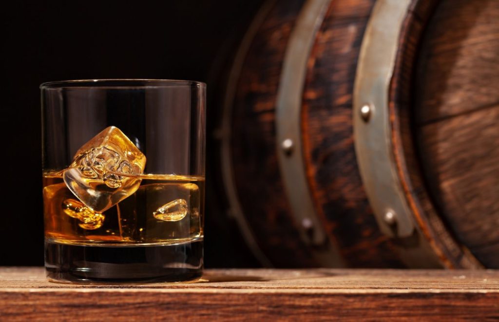 Cowboy whiskey in front of barrel at Cedar Point. Keep reading to learn about the Cedar Point Frontier Festival.