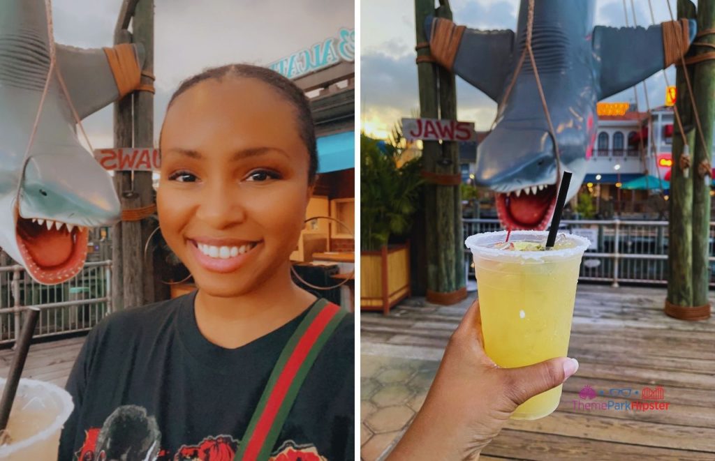 Universal Orlando Resort NikkyJ enjoying a margarita at Chez Alcatraz with Jaws Bruce the Shark in background at Universal Studios with ThemeParkHipster.