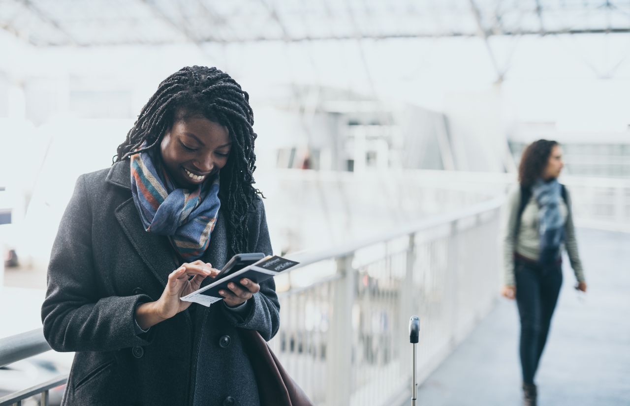 Black Lady Solo Traveler in the Airport looking for cheap flights to Orlando, Florida.