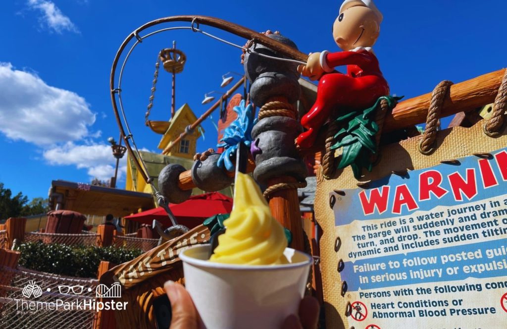 Universal Orlando Resort eating Dole Whip at Wimpy's in Islands of Adventure Toon Lagoon in front of Popeye Ride. Keep reading to get the 5 Cheapest, Best Food at Islands of Adventure UNDER $10.