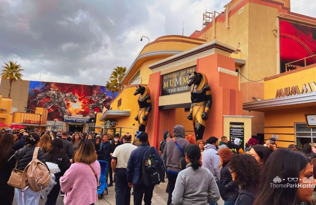 Universal Studios Hollywood Revenge of the Mummy and Transformers the Ride area with a crowd walking in front. Keep reading to find out more of the best Universal Studios Hollywood attractions.