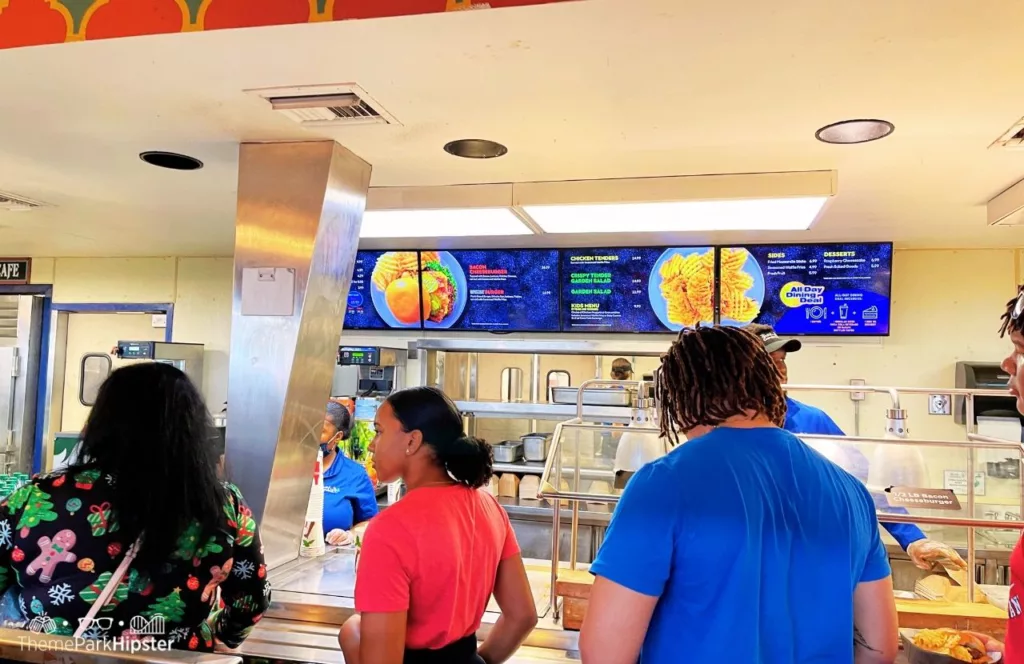 Busch Gardens Tampa Bay Zagora Cafe food menu with theme park guests standing at the counter. Keep reading discover more about Busch Gardens Tampa restaurants.