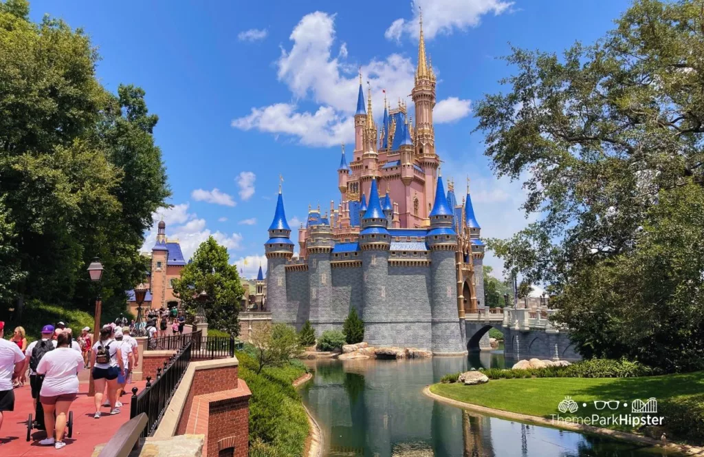 Disney Liberty Square View of Cinderella Castle at Magic Kingdom Theme Park on a crowded day. Keep reading to get your ultimate theme park planning guide.