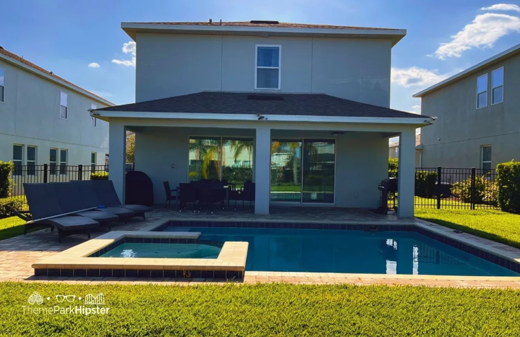 Pool area in 5 Bedroom villa at Encore Resort near Disney World with sun loungers and seating. Keep reading to hear more about Encore Resort.