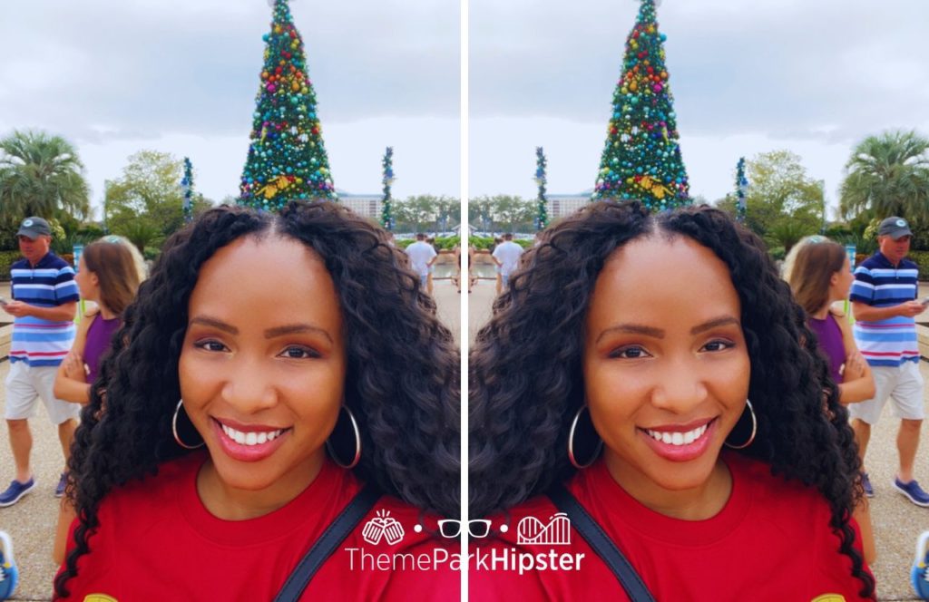 NikkyJ in front of Christmas tree at SeaWorld Orlando Christmas Celebration on a solo theme park trip!