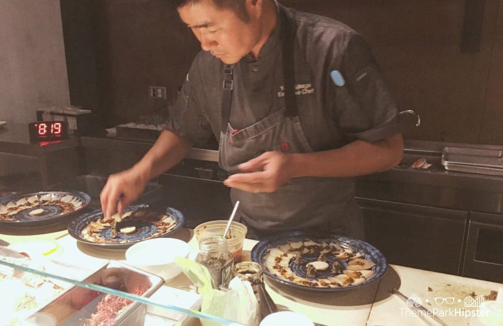 Walt Disney World Disney Springs Morimoto Asia Restaurant sushi chef making seafood dish. One of the best things for adult to do at Disney World.