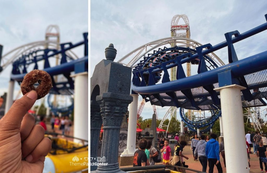 Cedar Point Amusement Park Ohio Mini Donuts with Corkscrew roller coaster in the background. Keep reading for more Cedar Point Solo Travel Tips!