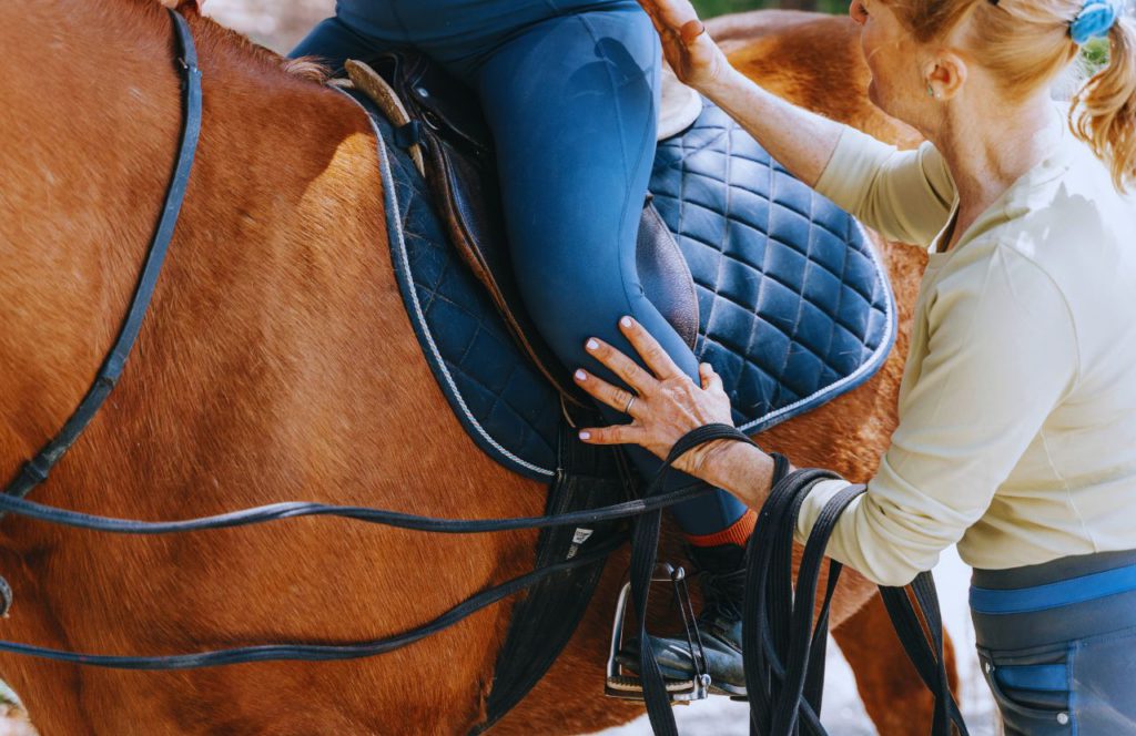 Lady helping rider on the horse